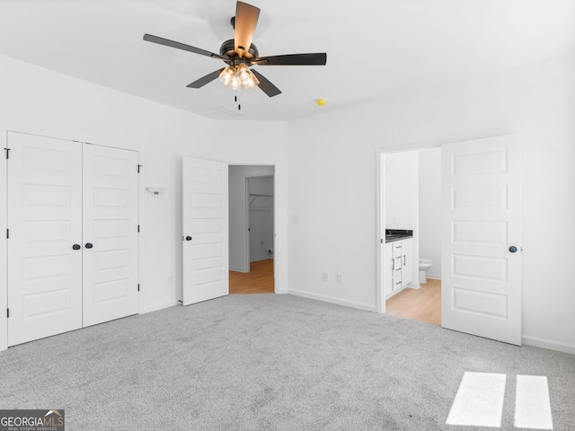 1215 White Oak Way, Griffin, GA 30224 - unfurnished bedroom with light colored carpet, ensuite bath, a closet, and baseboards