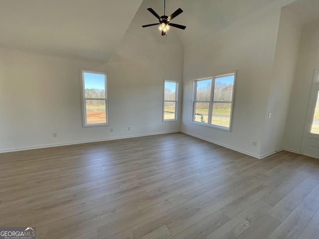 unfurnished living room with ceiling fan, light hardwood / wood-style floors, and high vaulted ceiling