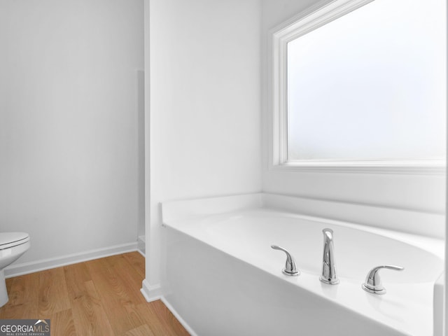 1215 White Oak Way, Griffin, GA 30224 - full bathroom featuring a bath, toilet, wood finished floors, and baseboards