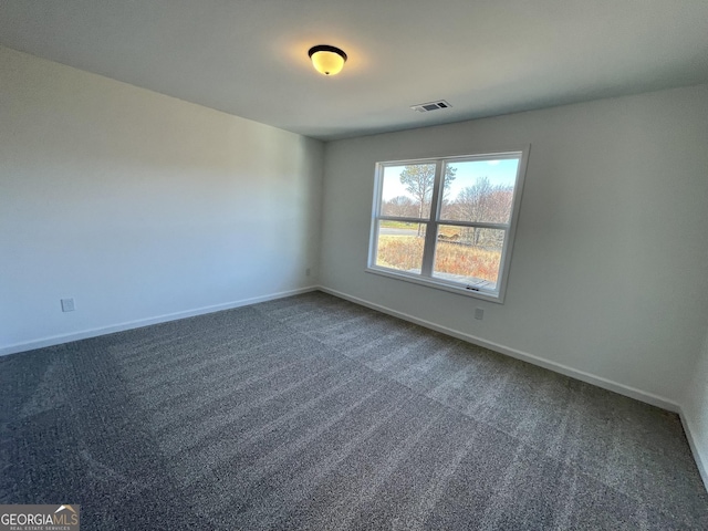 unfurnished room with dark colored carpet