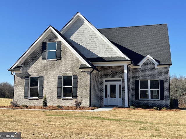 view of property featuring central AC unit and a front lawn