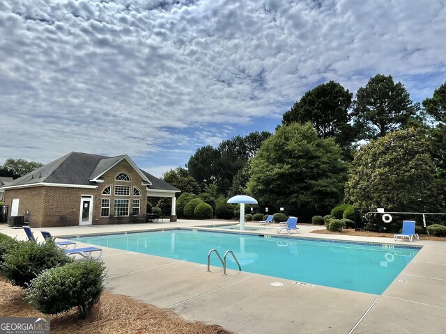 1215 White Oak Way, Griffin, GA 30224 - community pool featuring a patio, an exterior structure, an outbuilding, view of scattered trees, and central air condition unit