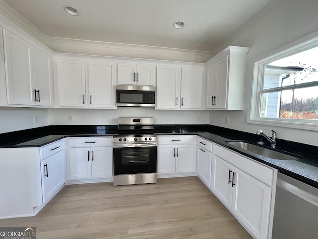 kitchen with white cabinets, sink, light wood-type flooring, and stainless steel appliances