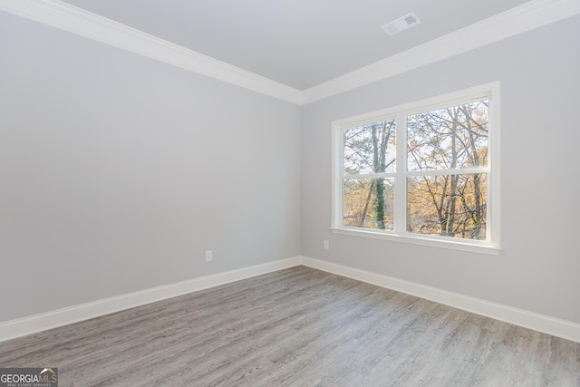 spare room with crown molding and light wood-type flooring