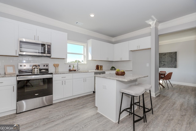 kitchen featuring stainless steel appliances, ornamental molding, visible vents, and decorative backsplash