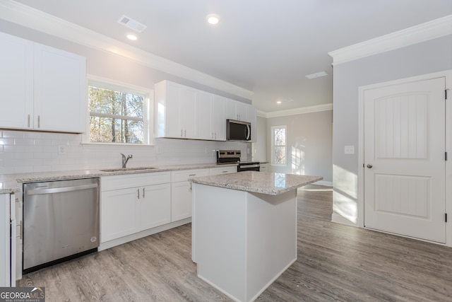 kitchen featuring a center island, sink, white cabinets, and appliances with stainless steel finishes