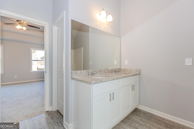 bathroom with hardwood / wood-style floors, vanity, and ceiling fan