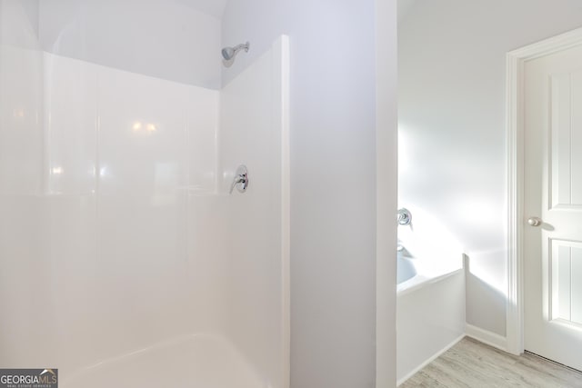 bathroom with wood-type flooring and independent shower and bath