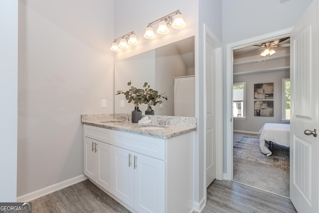 bathroom with ensuite bathroom, ceiling fan, wood finished floors, vanity, and baseboards