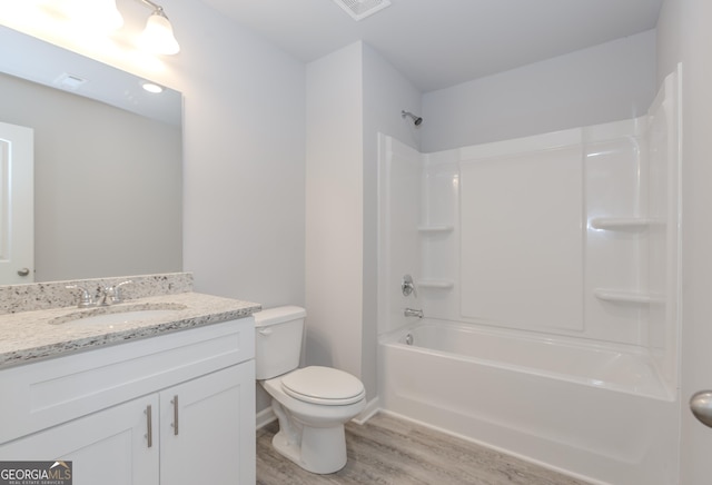 bathroom featuring visible vents, toilet, wood finished floors, tub / shower combination, and vanity