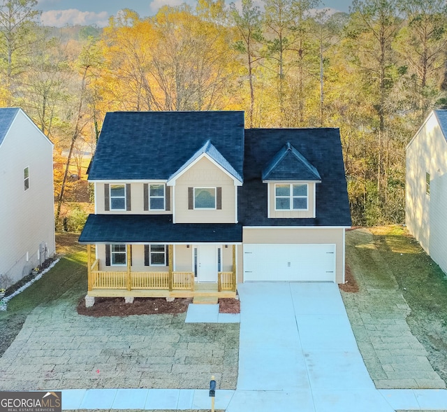 view of front of home featuring a porch, a garage, and a front lawn