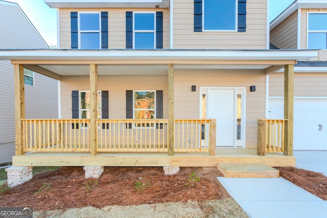 entrance to property with covered porch and an attached garage