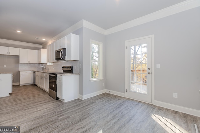 kitchen featuring appliances with stainless steel finishes, tasteful backsplash, light stone counters, sink, and white cabinetry