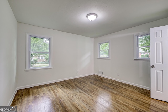 unfurnished room featuring dark hardwood / wood-style flooring and a textured ceiling