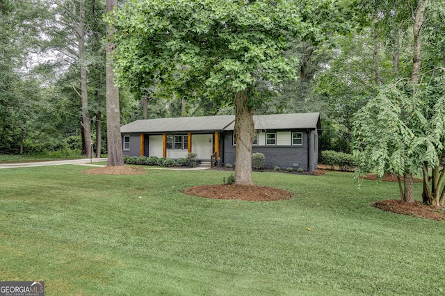 ranch-style house featuring covered porch and a front lawn