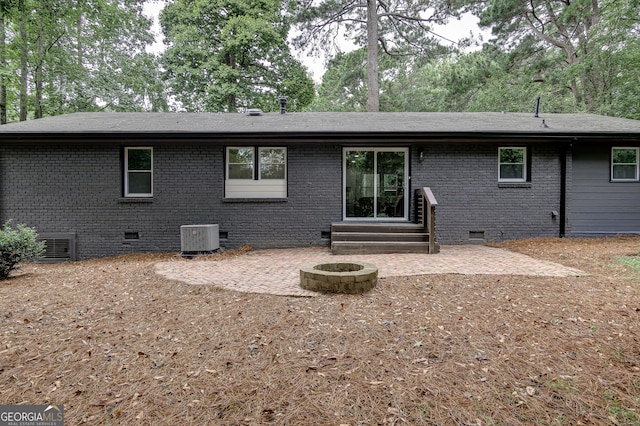 rear view of property with central AC unit, an outdoor fire pit, and a patio area