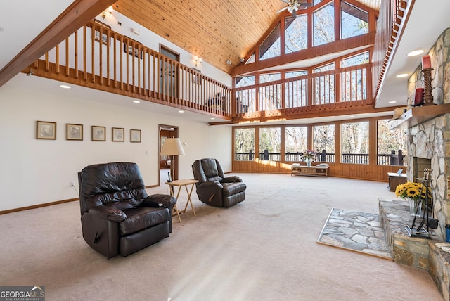 carpeted living room featuring a healthy amount of sunlight, wood ceiling, a fireplace, and high vaulted ceiling