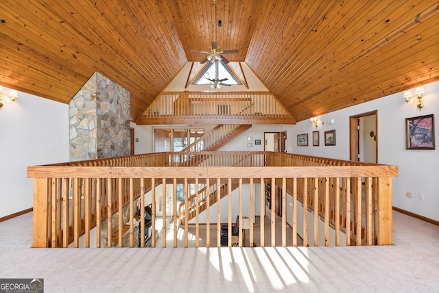 staircase featuring carpet flooring, a skylight, ceiling fan, and wooden ceiling