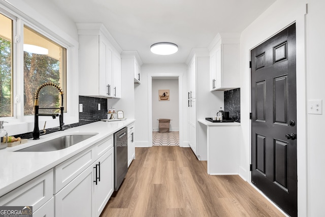 kitchen featuring dishwasher, decorative backsplash, sink, and white cabinets