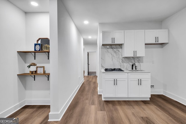 kitchen with white cabinets, sink, decorative backsplash, gas stovetop, and dark hardwood / wood-style flooring