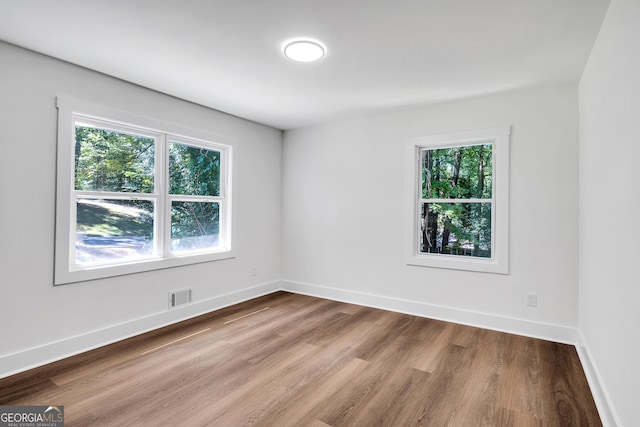 empty room with hardwood / wood-style floors and a wealth of natural light