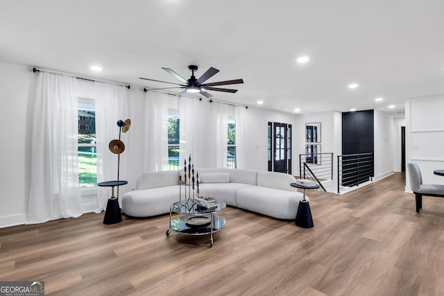 living room with light wood-type flooring and ceiling fan