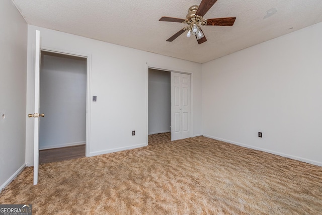 unfurnished bedroom featuring carpet, a textured ceiling, and ceiling fan