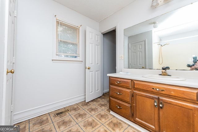 bathroom featuring tile patterned floors, vanity, and walk in shower