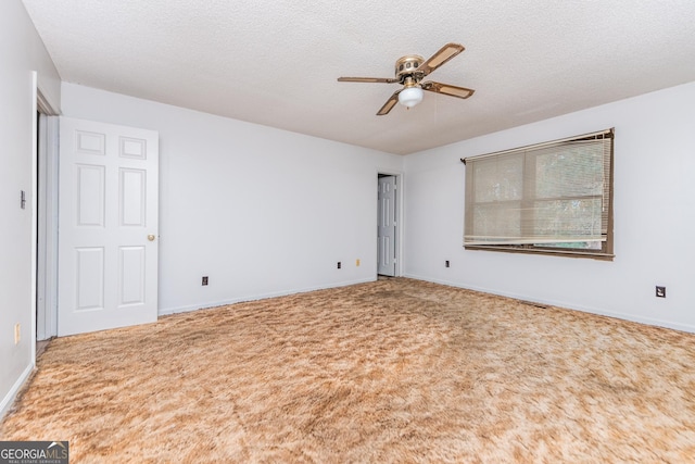 carpeted spare room with ceiling fan and a textured ceiling