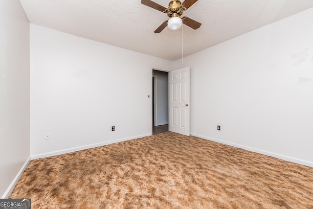 carpeted spare room featuring ceiling fan and a textured ceiling