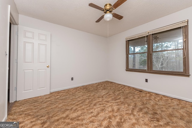 carpeted spare room with a textured ceiling and ceiling fan