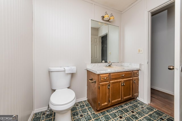 bathroom with hardwood / wood-style flooring, crown molding, vanity, and toilet