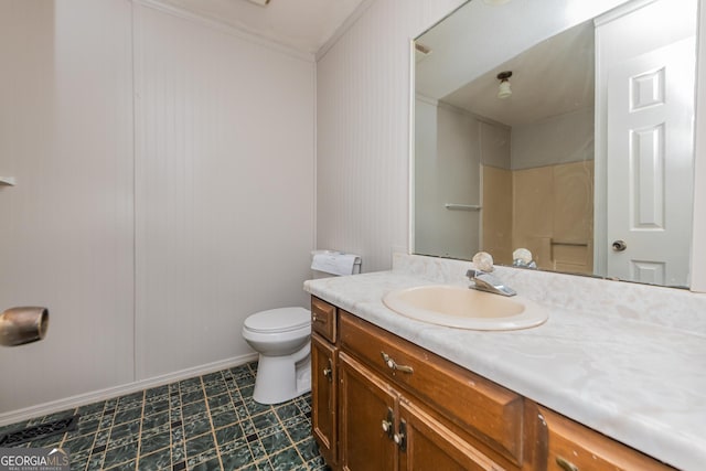 bathroom with vanity, toilet, and crown molding