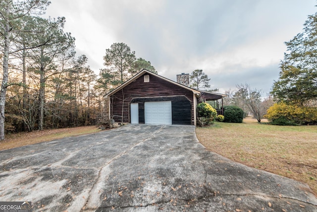 view of side of home featuring a lawn, a carport, and a garage