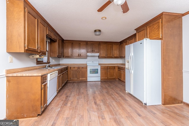 kitchen with white appliances, a textured ceiling, and light hardwood / wood-style flooring