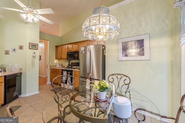 tiled dining space with a high ceiling and ceiling fan with notable chandelier