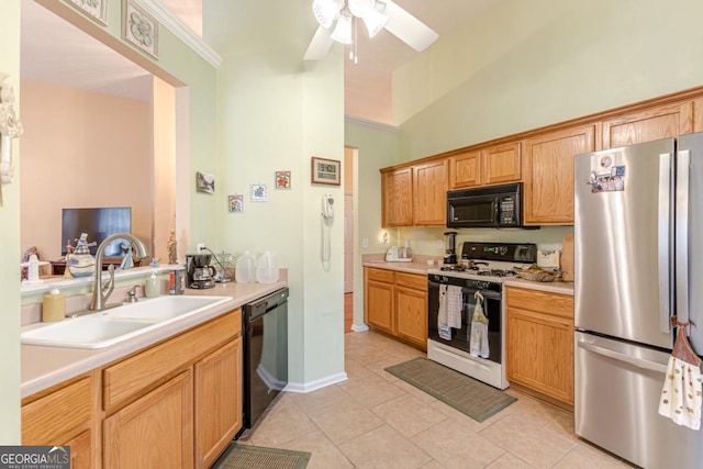 kitchen featuring ceiling fan, sink, a towering ceiling, light tile patterned floors, and black appliances