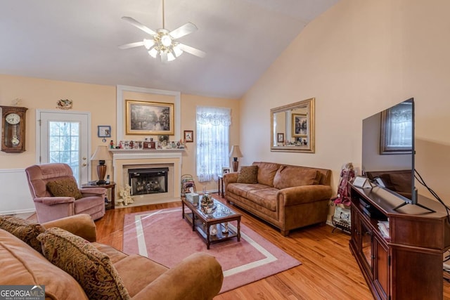 living room with light wood-type flooring, ceiling fan, and lofted ceiling