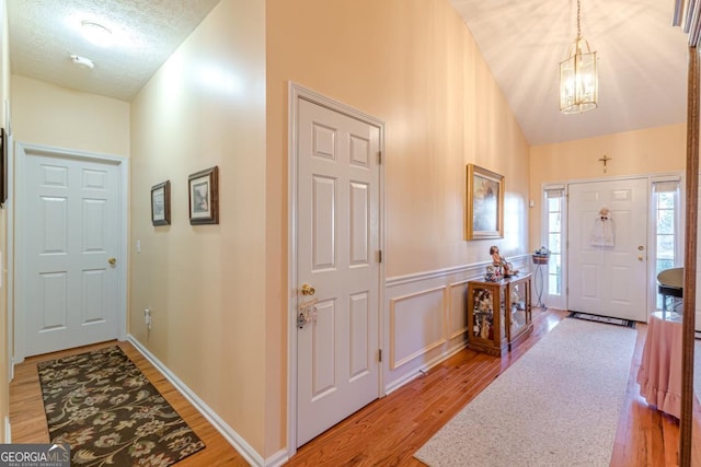 foyer entrance with hardwood / wood-style floors, a chandelier, and a textured ceiling