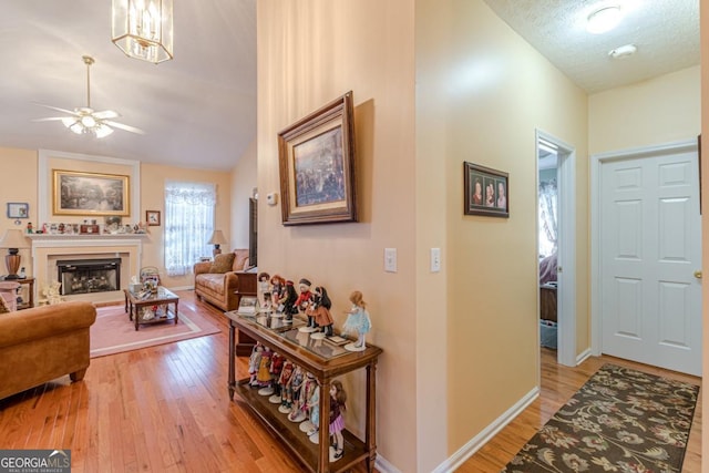 interior space featuring a textured ceiling, an inviting chandelier, light hardwood / wood-style flooring, and vaulted ceiling