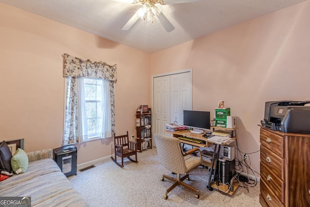 carpeted office space featuring ceiling fan and a textured ceiling