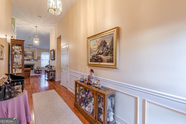 hall with hardwood / wood-style floors and an inviting chandelier