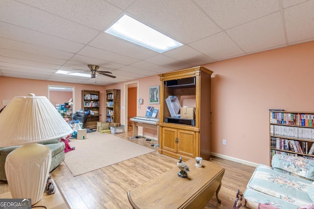 living room with a drop ceiling and light hardwood / wood-style floors