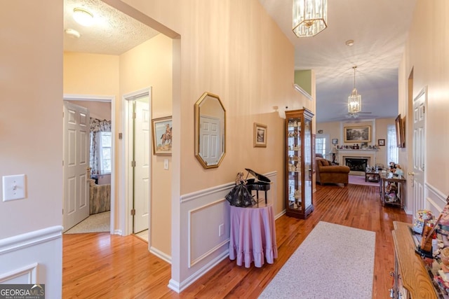 hallway with wood-type flooring and an inviting chandelier