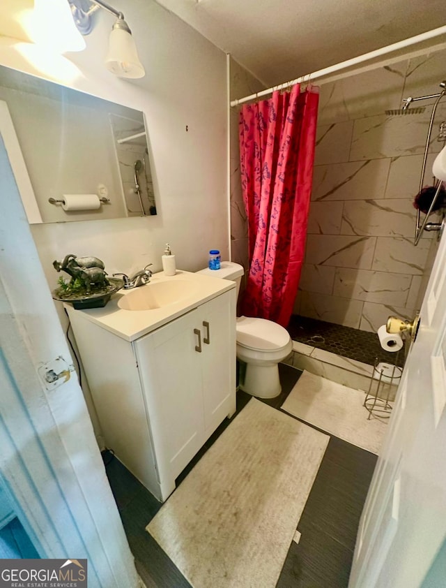 bathroom with toilet, vanity, and walk in shower