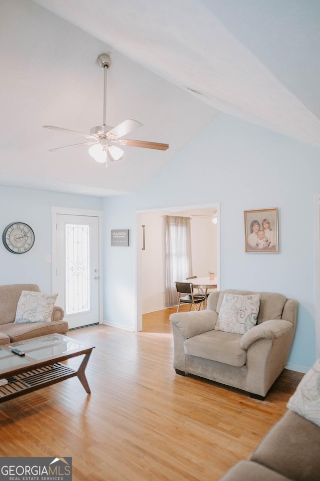 living room featuring light hardwood / wood-style floors, high vaulted ceiling, and ceiling fan