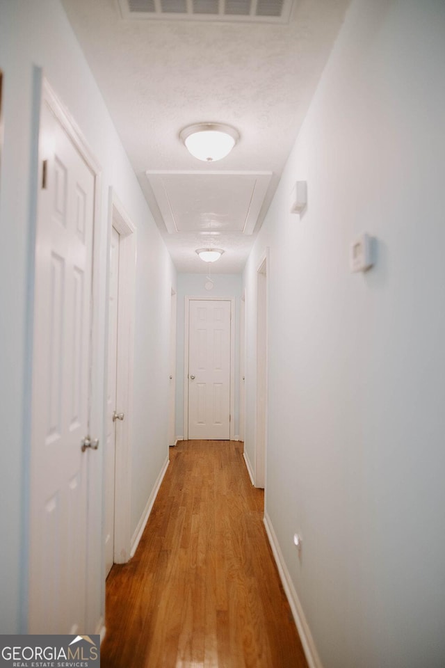 corridor with wood-type flooring