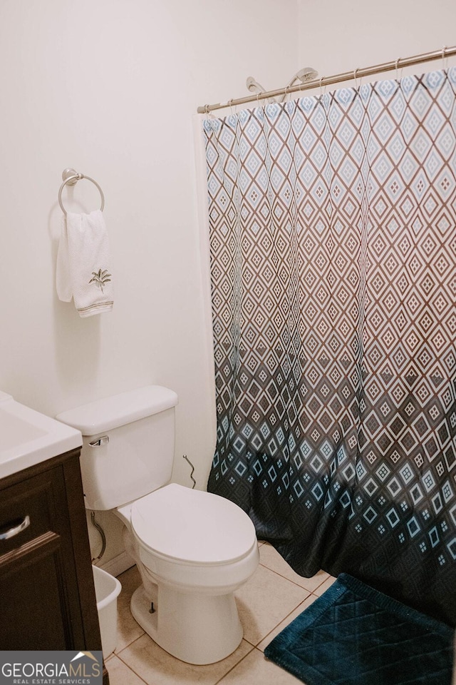 bathroom with tile patterned flooring, vanity, and toilet