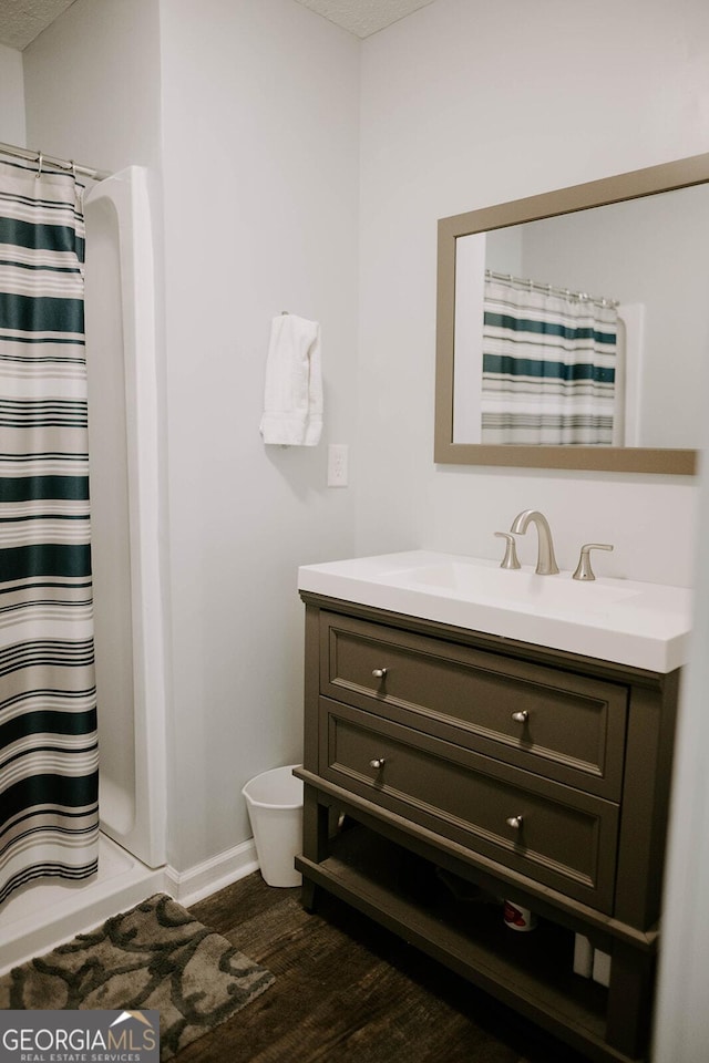 bathroom with hardwood / wood-style flooring, vanity, a textured ceiling, and a shower with shower curtain