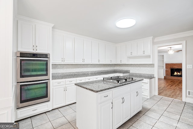 kitchen featuring white cabinetry, dark stone counters, and appliances with stainless steel finishes